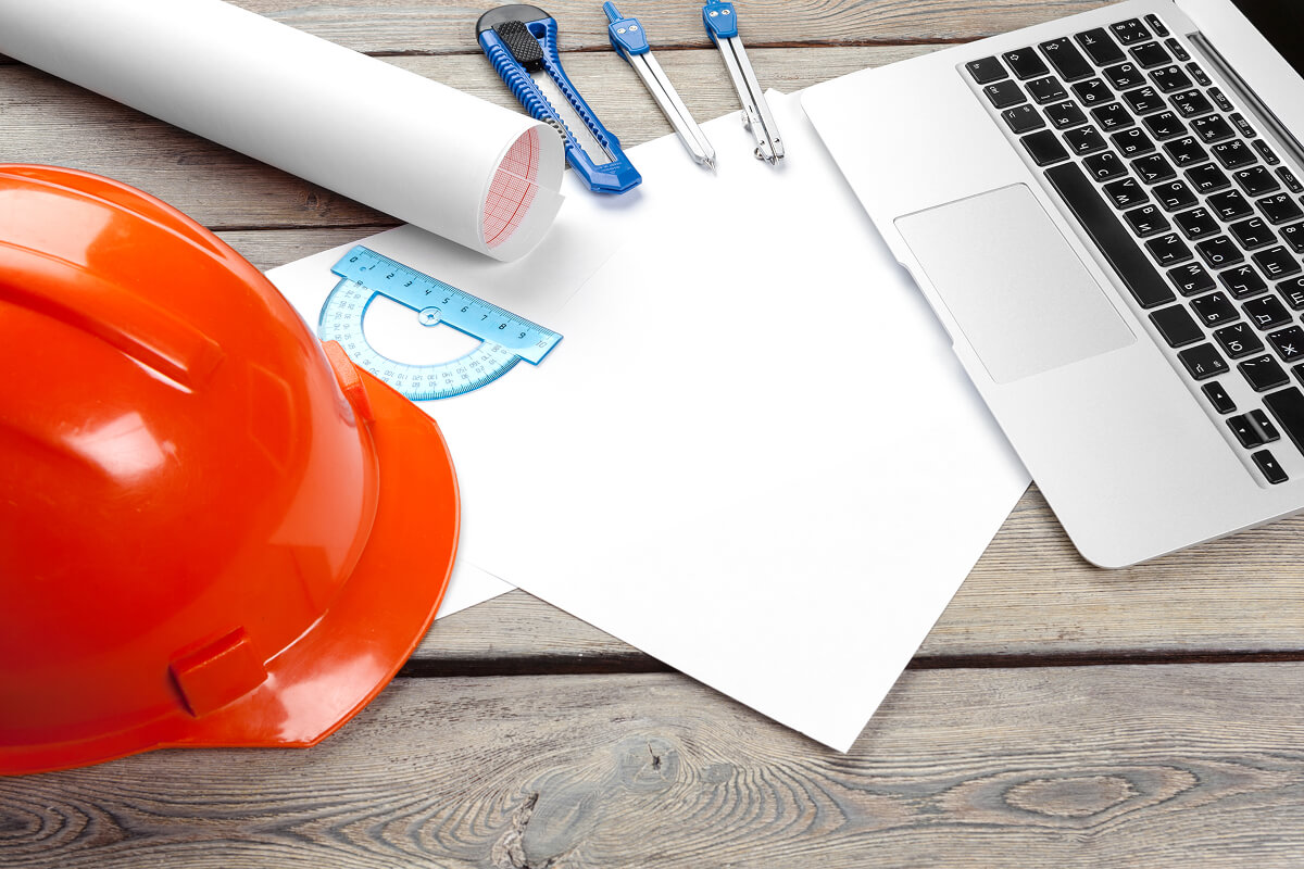 Architect workspace with laptop and drafting tools