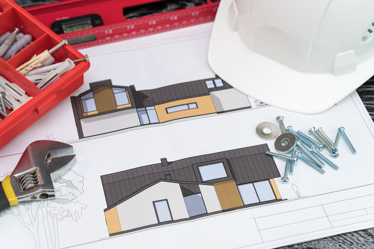 Construction blueprints, hard hat, and tools laid out for site planning
